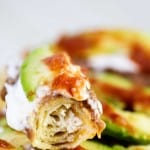 Tacos Dorados or fried tacos filled with tender chicken and cheese and topped with beans, sour cream, avocado, and salsa