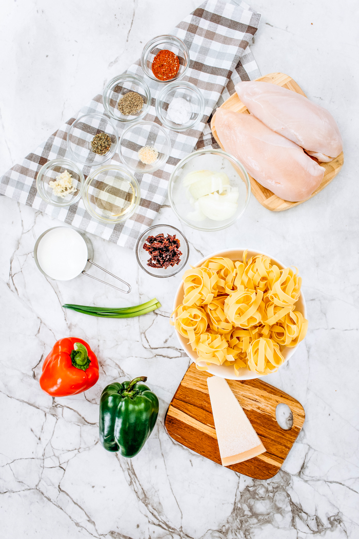 Ingredients with chicken breast, noodles and all spices for Cajun Chicken Pasta Skillet
