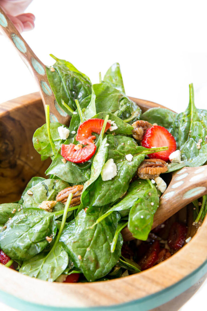 Strawberry Pecan Spinach Salad with a balsamic vinaigrette in a wooden bowl.