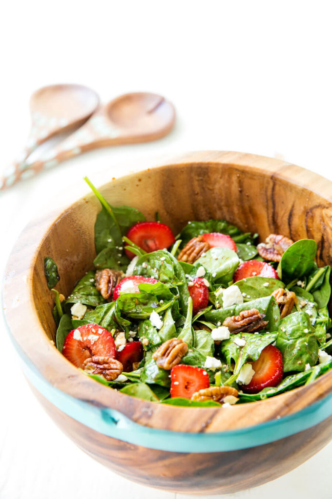 Strawberry Pecan Spinach Salad with a balsamic vinaigrette in a wooden bowl.