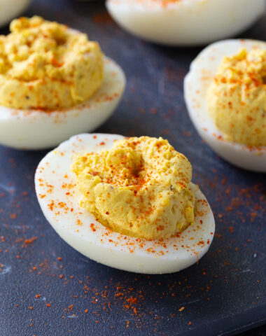 Classic deviled eggs arranged on a serving platter, filled with a creamy yolk mixture and garnished with a sprinkle of paprika – the perfect appetizer for holidays, parties, and potlucks.