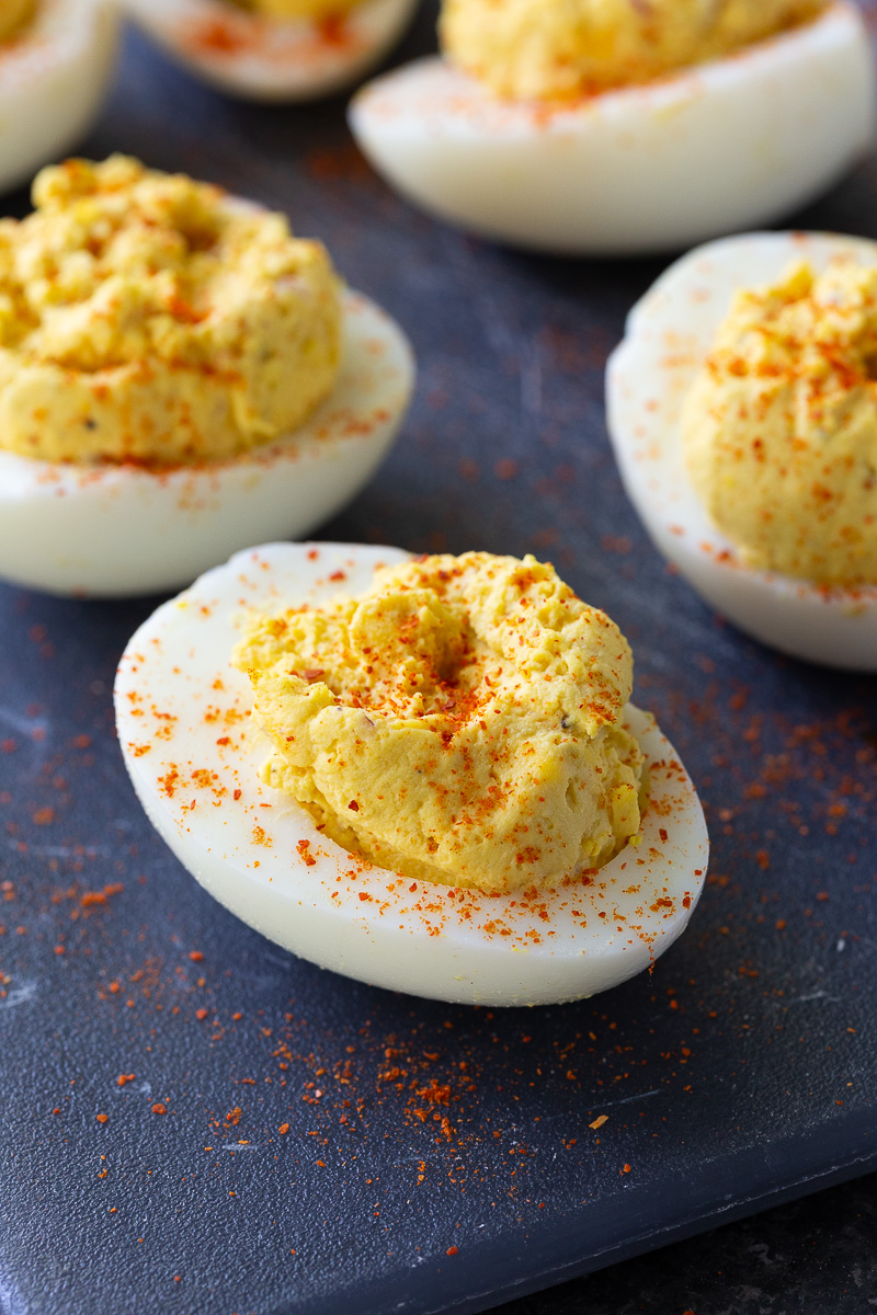 Classic deviled eggs arranged on a serving platter, filled with a creamy yolk mixture and garnished with a sprinkle of paprika – the perfect appetizer for holidays, parties, and potlucks.