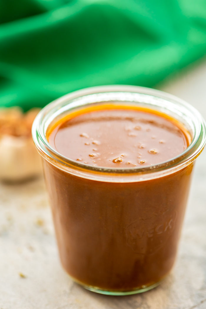 Homemade enchilada sauce in glass jar.