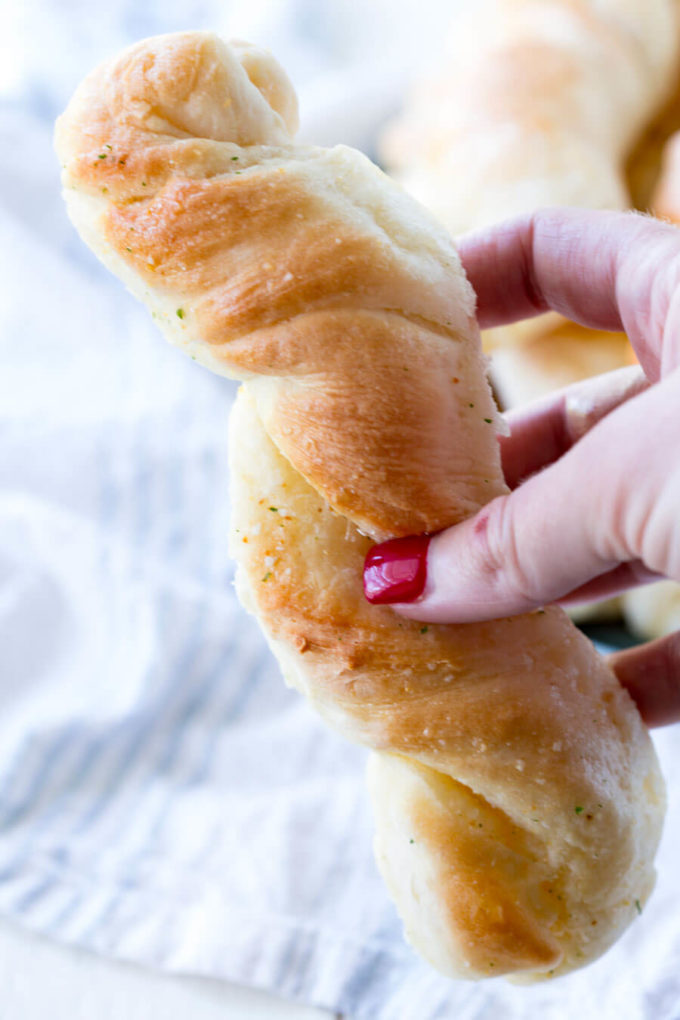 delicious garlic bread twist held in a female hand 