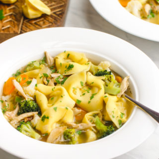 A big white bowl of chicken tortellini soup