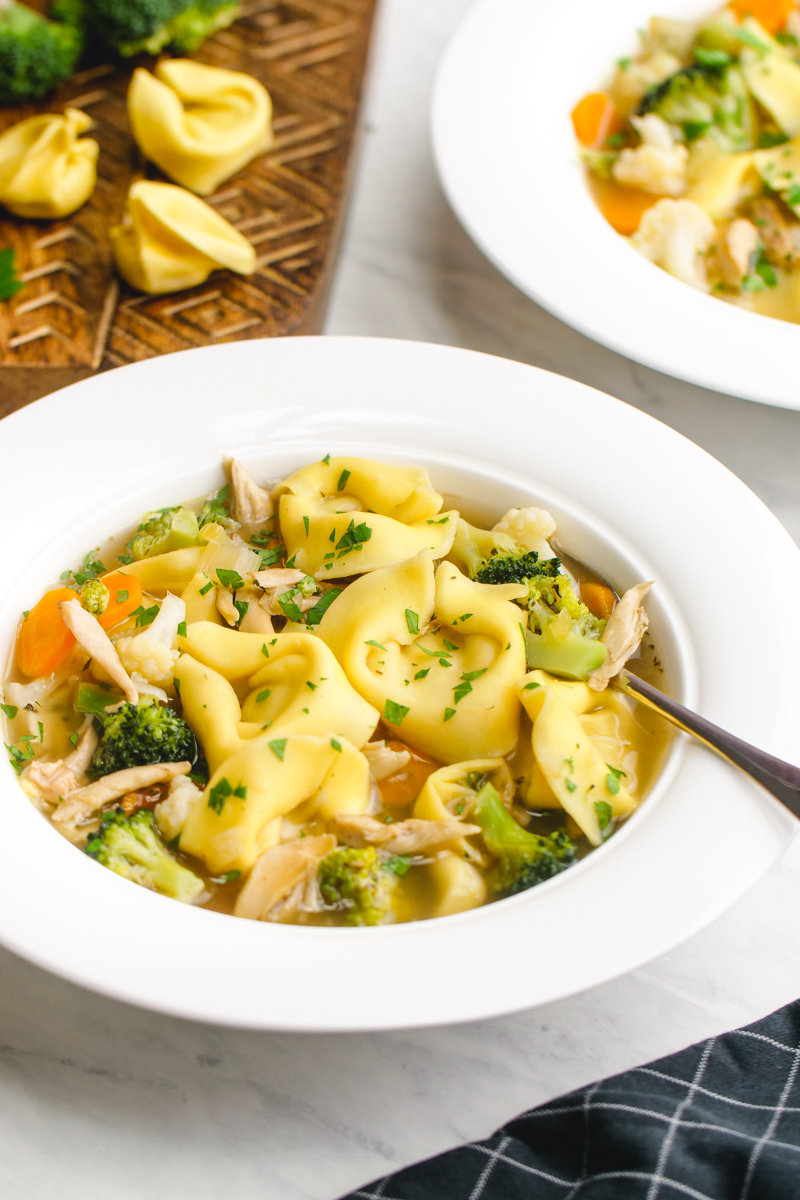 A big white bowl of chicken tortellini soup