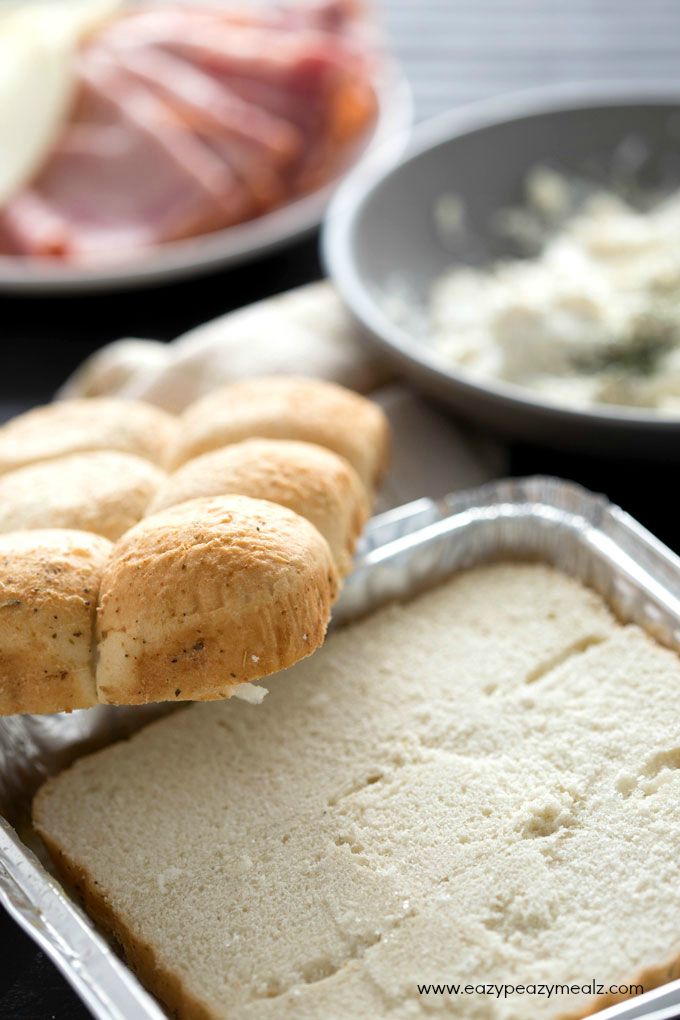 Cheesy Ham and Garlic Sandwich Bake: a tray of rolls just sliced in half ready to fill and bake