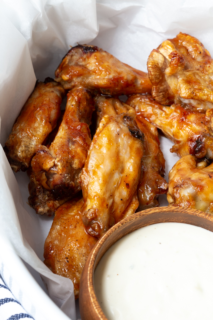 Perfectly crispy air fried wings in a basket with sauce