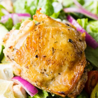 Baked Greek Chicken Thighs on a bed of lettuce