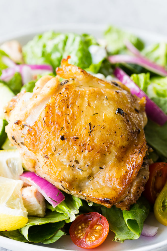 Baked Greek Chicken Thighs on a bed of lettuce