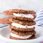 A stack of three brownie cookie sandwiches with a peppermint buttercream filling