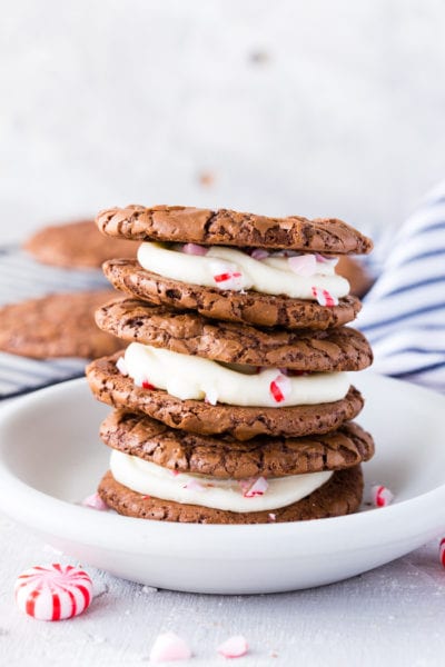 A stack of three brownie cookie sandwiches with a peppermint buttercream filling