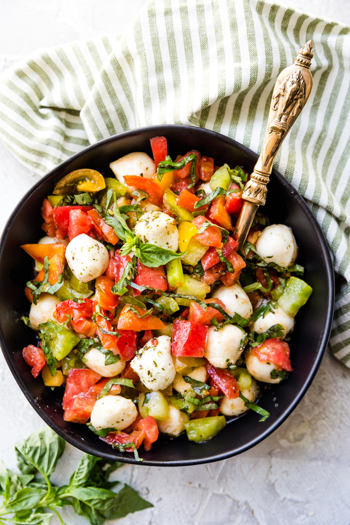 Caprese salad in a black bowl.