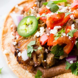 These carnitas tostadas are crispy, with black beans, the best carnitas, and all your favorite toppings.
