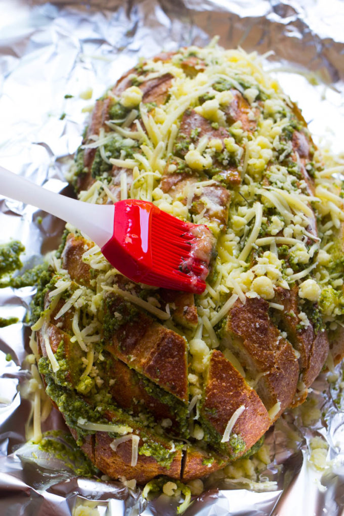 This scrumptious pull apart bread full of cheesy goodness and pesto is the ideal way to use up all that fresh basil hanging around in your garden now! Plus there has never been an easier way to make day old bread taste scrumptiously delicious!
