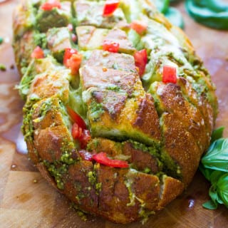 This scrumptious pull apart bread full of cheesy goodness and pesto is the ideal way to use up all that fresh basil hanging around in your garden now! Plus there has never been an easier way to make day old bread taste scrumptiously delicious!