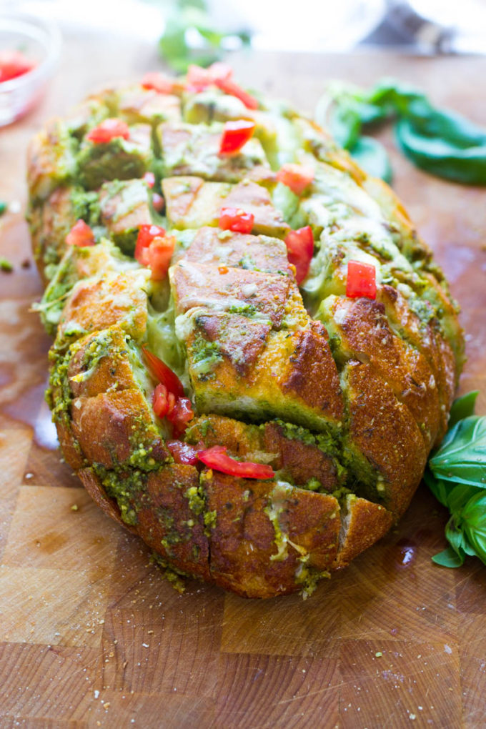 This scrumptious pull apart bread full of cheesy goodness and pesto is the ideal way to use up all that fresh basil hanging around in your garden now! Plus there has never been an easier way to make day old bread taste scrumptiously delicious!