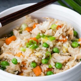 Chicken fried rice in a white bowl with a black chopstick