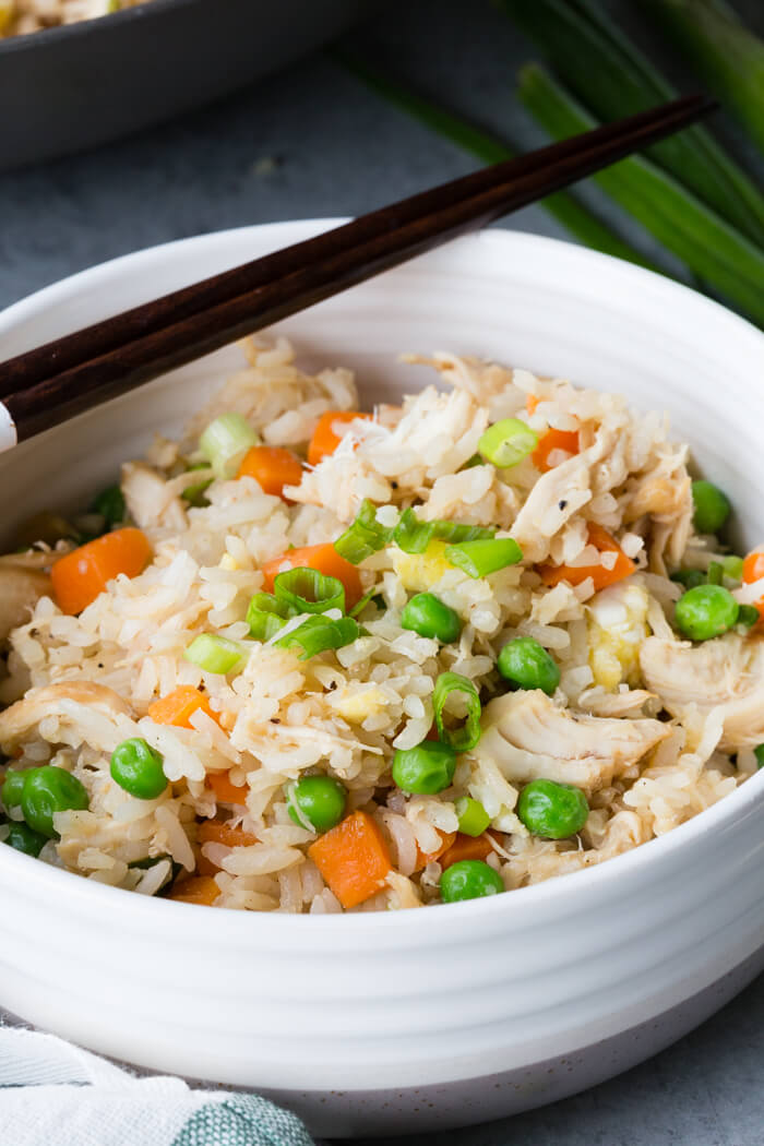 Chicken fried rice in a white bowl with a black chopstick