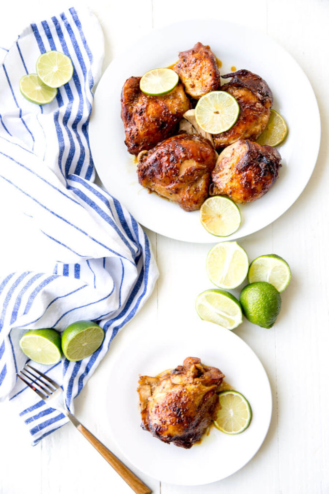 Crockpot Garlic Lime Chicken on white plate, garnished with fresh lime slices.