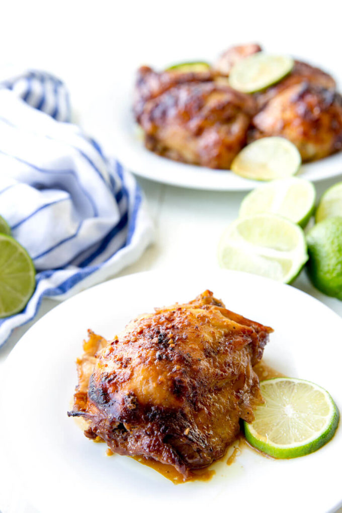 Crockpot Garlic Lime Chicken on white plate with a fresh slice of lime.