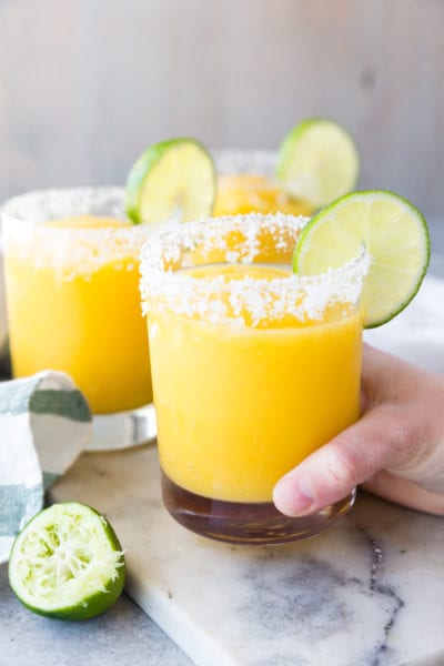 Mango Margaritas raise a glass, salted rim, with lime, frozen