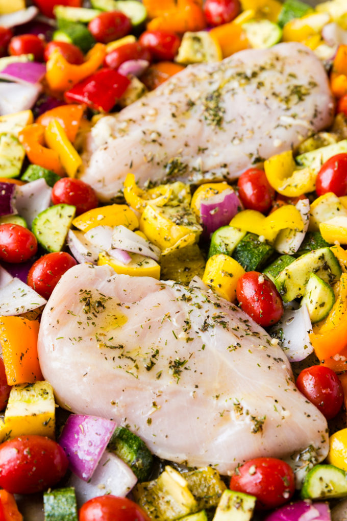 Uncooked chicken in a pan with veggies