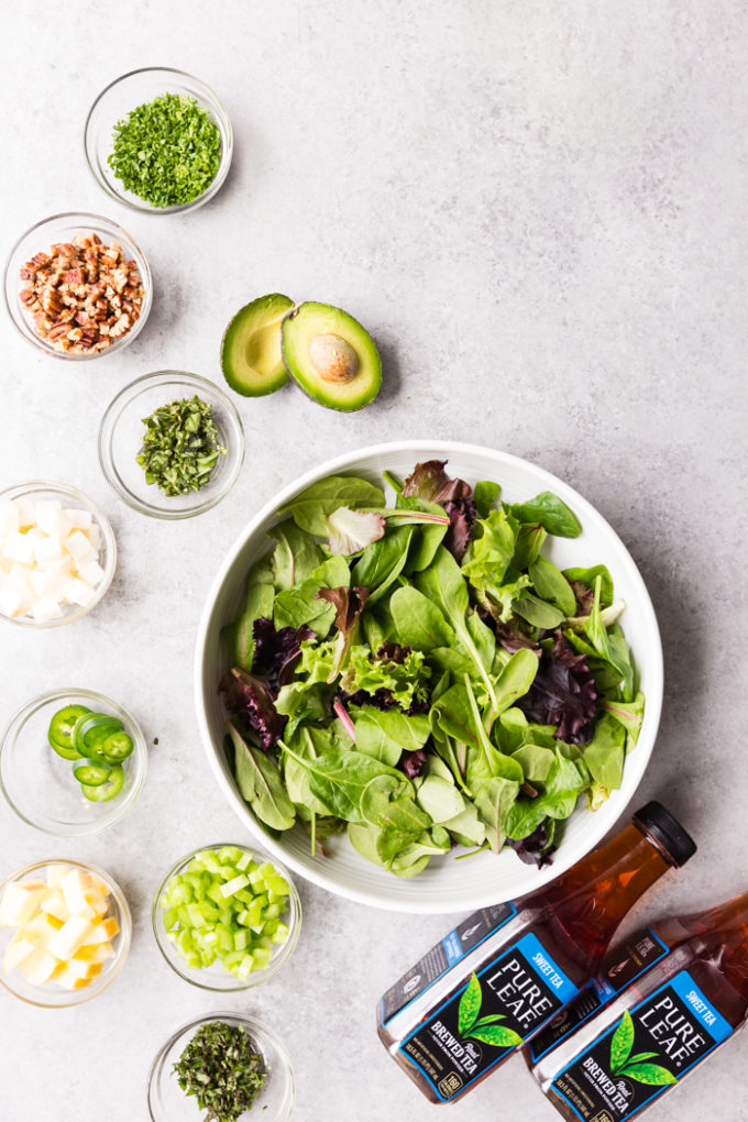 Grilled Chicken Salad with all the ingredients around the big bowl of lettuce. 