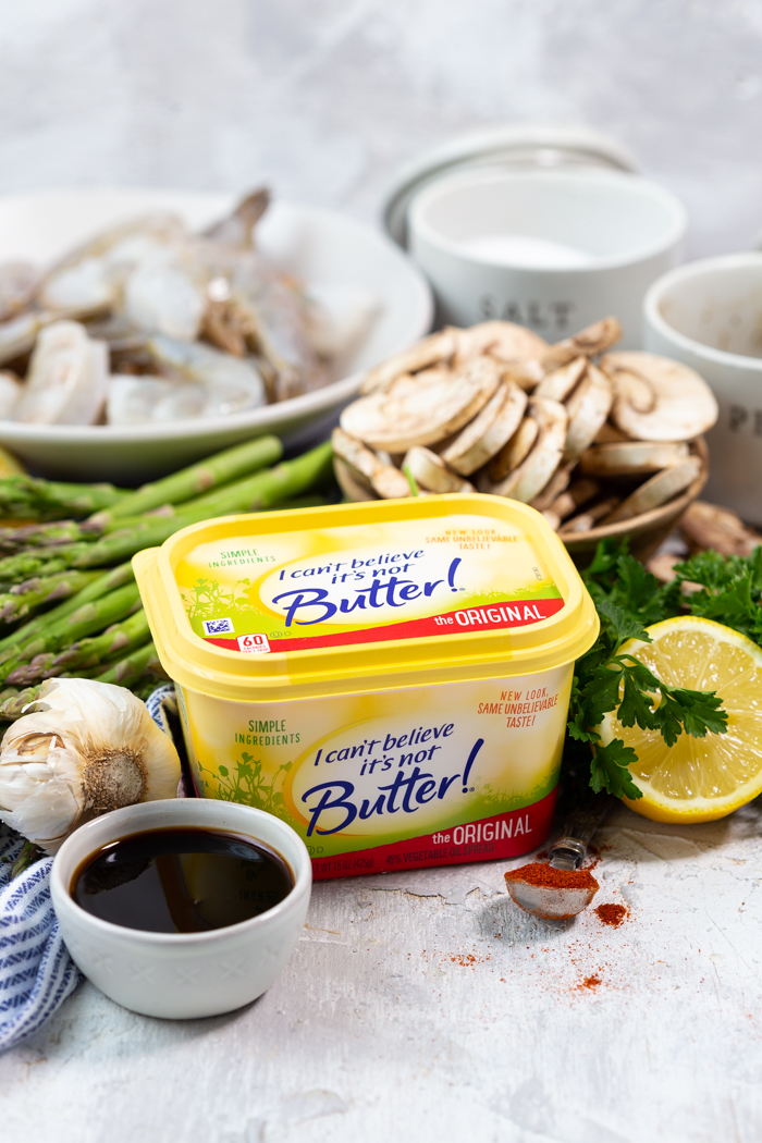 Ingredients needed for a low calorie sheet pan dinner of shrimp and asparagus and mushrooms with a honey lemon garlic sauce