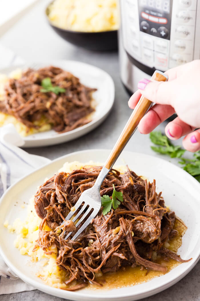 Instant Pot Mississippi Pot Roast on a bed of mashed potatoes 