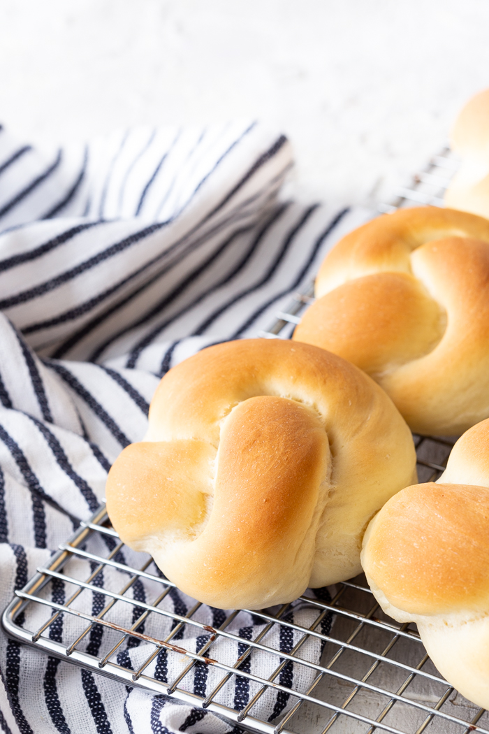 Mom's Dinner Rolls, on a cooling rack with a blue and white striped linen