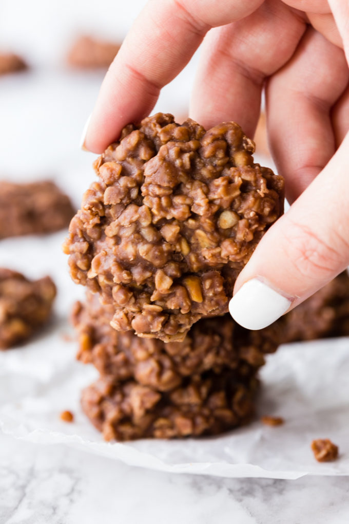 Making no bake cookies, a hand holding one on top of a stack. 