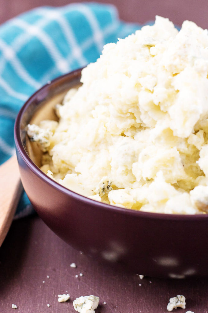 Roasted Garlic Bleu Cheese Mashed Potatoes in a brown bowl with a blue towel.