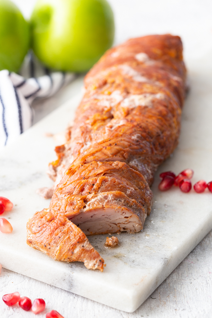 A roasted pork tenderloin on a marble cutting board