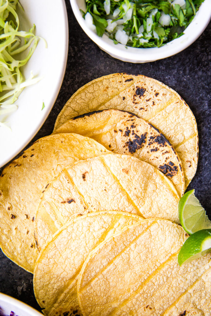 Corn tortillas that have been grilled or heated over open flame for shredded beef tacos