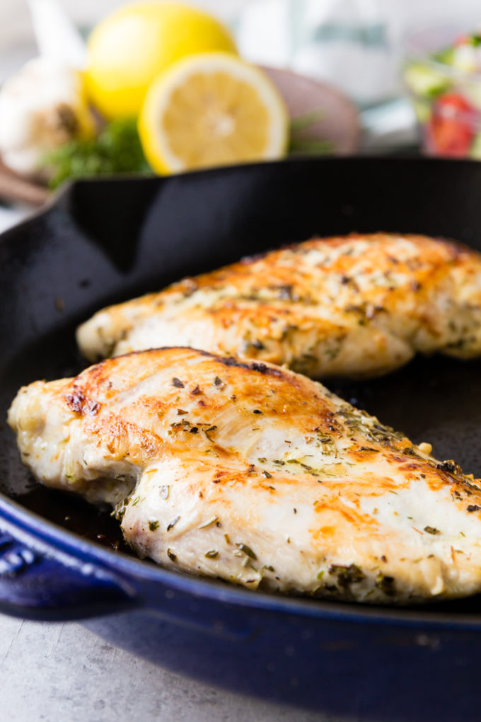 skillet greek chicken cooking in the skillet lemon in background