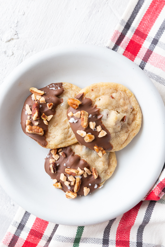 Toffee pecan christmas cookies on a white plate with a red plaid napkin