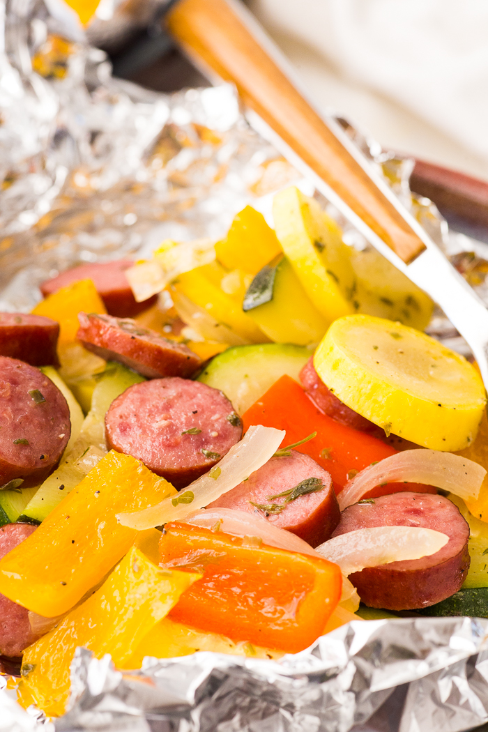 A grill pouch loaded with sausage and vegetables