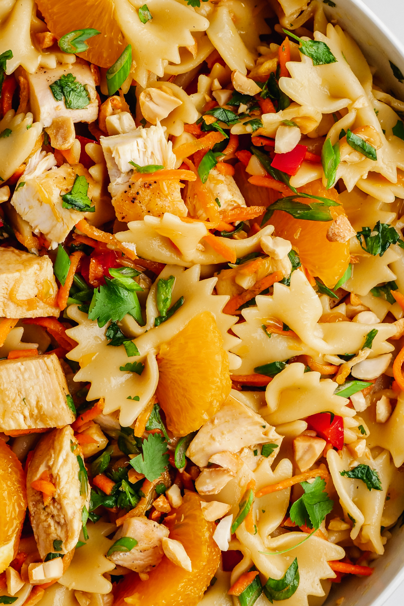 A close up of the pasta, chicken, mandarins, and other ingredients in Asian Pasta Salad