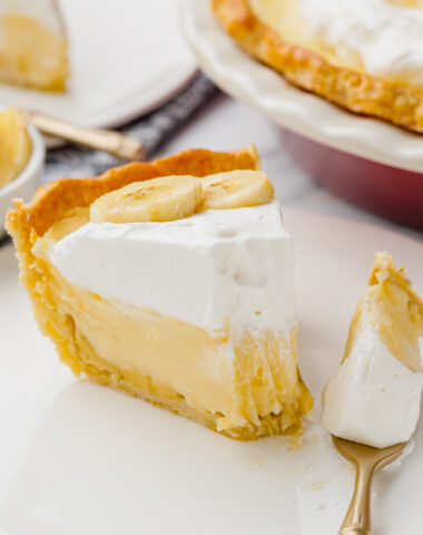 banana creme pie on white plate with fork into it