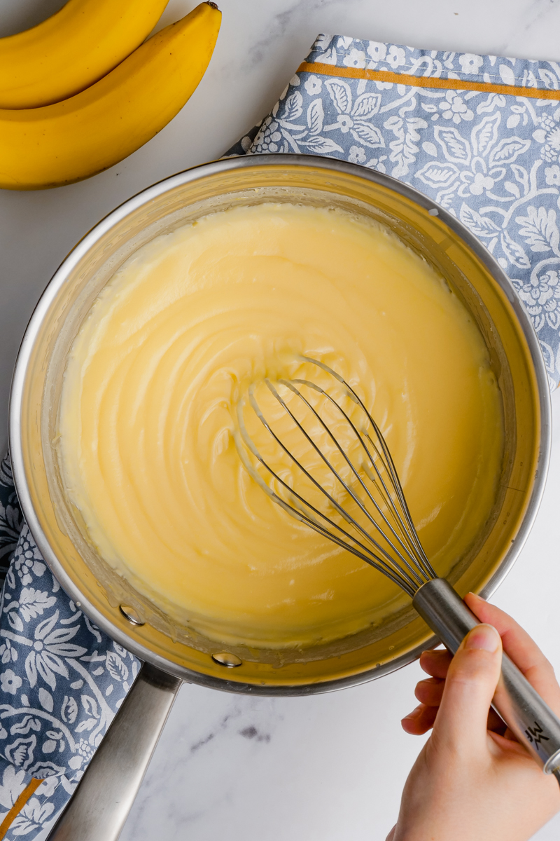 banana creme pie filling being whisked in a metal bowl