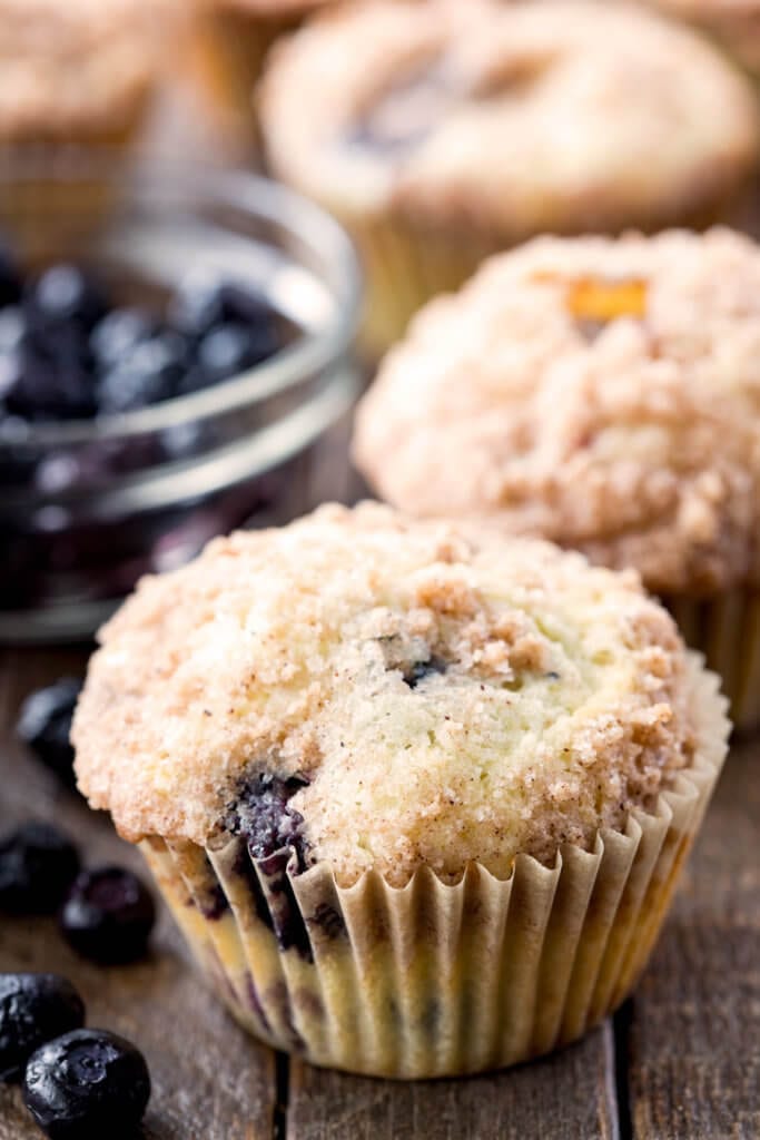 Blueberry Muffins with a clear bowl of blueberries.