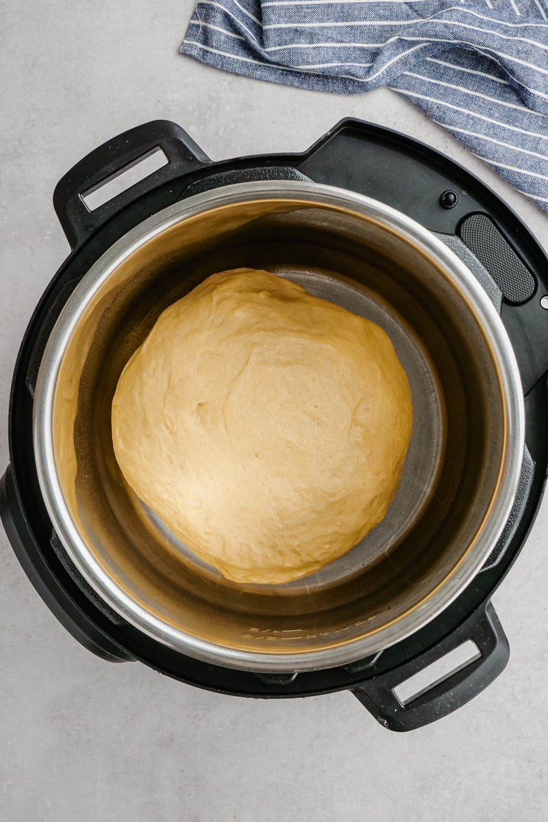 An instant pot set to the yogurt setting to let the dough rise.