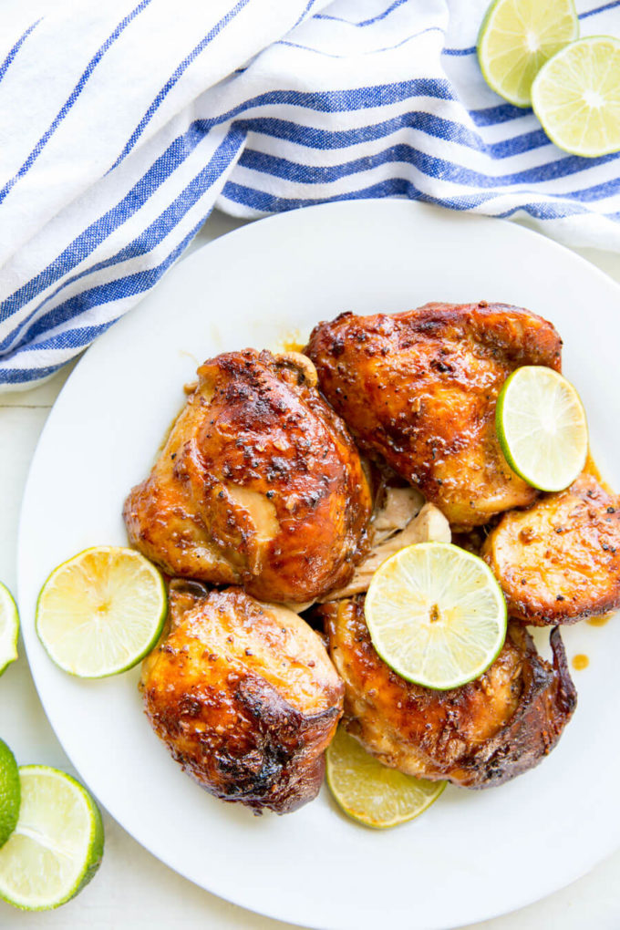 Garlic Lime Chicken on white plate garnished with fresh cut lime. 