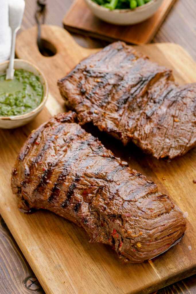 Making a grilled skirt steak, resting the meat on a cutting board after grilling. 