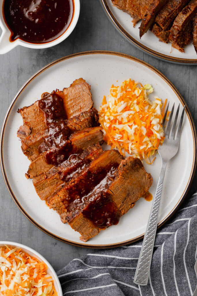 instant pot brisket on white plate with fork to the side and mashed potatoes