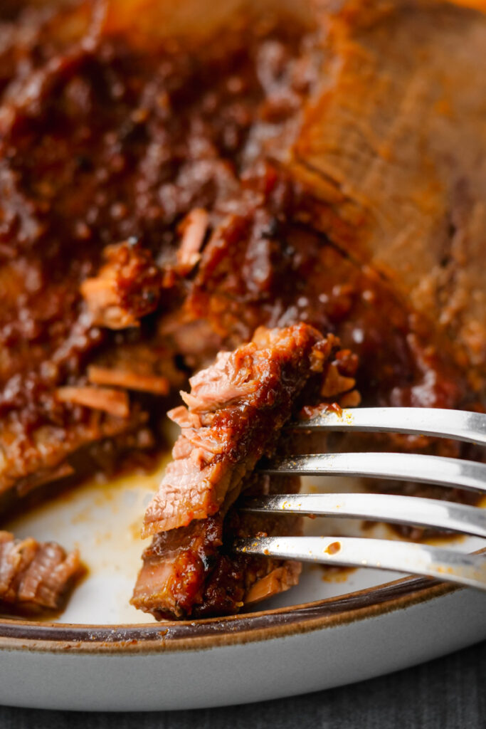 instant pot brisket on plate with fork to the side