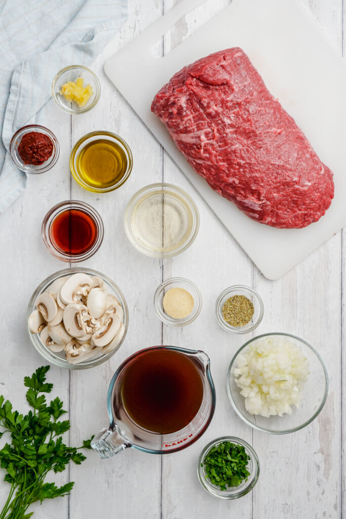 ingredient to Instant Pot Sirloin Roast Beef with Mushroom Sauce on a white table and cutting board