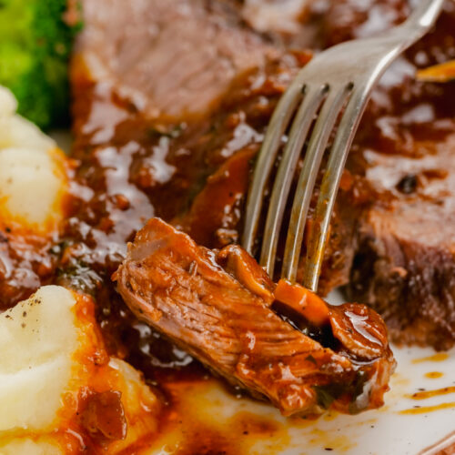 this delicious Instant Pot Sirloin Roast Beef with Mushroom Sauce on a white plate with fork into it with broccoli and mashed potatoes to the side.