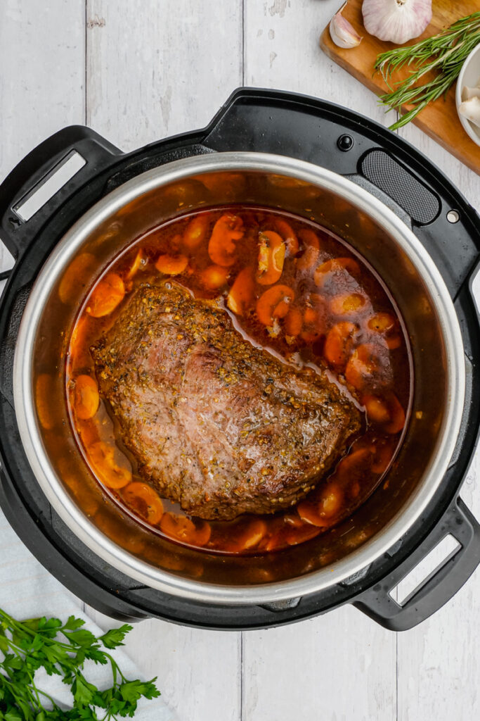 Instant Pot Sirloin Roast Beef with Mushroom Sauce in a instant pot with basil on the side